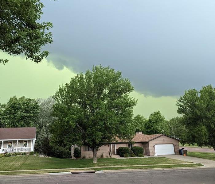 Photograph of storm cell moving through Sioux Falls with a green sky and dark clouds. 